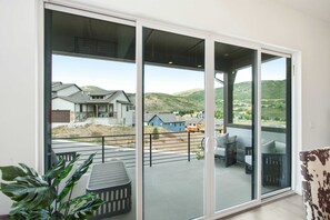 A modern house with a large sliding glass door leading to a covered outdoor area with a patio and seating. - 4 Bedroom Deer Valley East Townhome (Hideout)