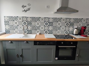 A kitchen with a Bosch dishwasher, a Valerio oven, a sink, and a coffee maker on the counter.