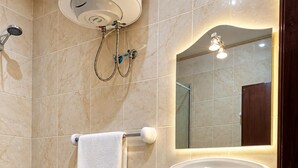 A bathroom with a shower, a sink, a toilet, and a mirror. - Sakab Al Aseel Hotel  (Makkah)