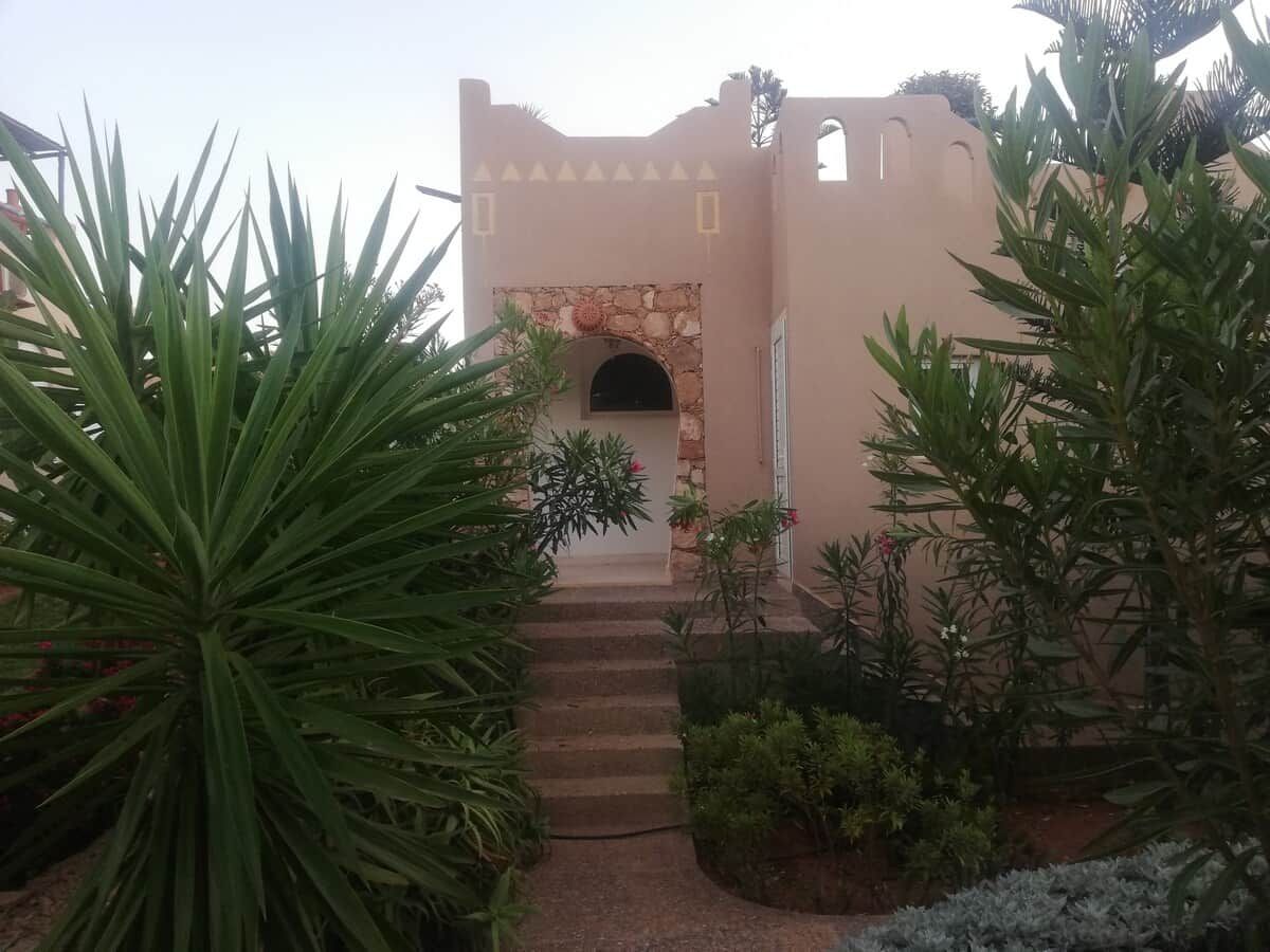 A building with a stone archway and steps leading to a door.