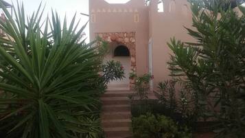 A building with a stone archway and steps leading to a door.