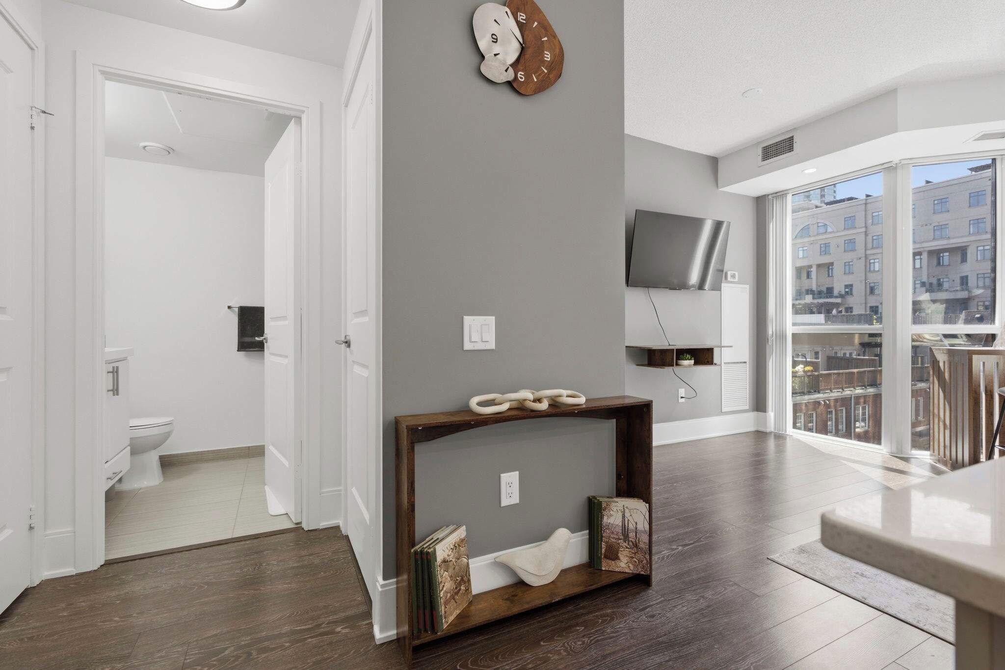 Eine moderne Wohnung mit Wohnbereich, einem Balkon mit Blick und einem Badezimmer.