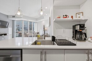 Una cocina moderna con una isla grande, una cafetera y vistas a la ciudad.