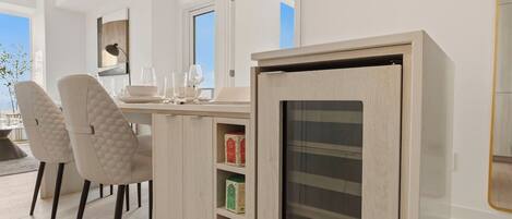 Una cocina moderna con horno empotrado, un comedor con sillas y vistas al exterior.