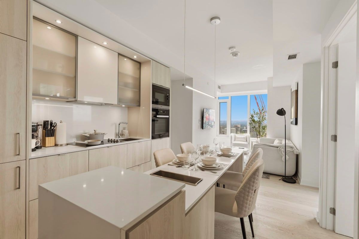 Una cocina moderna con una isla central, electrodomésticos integrados y un comedor con vistas.