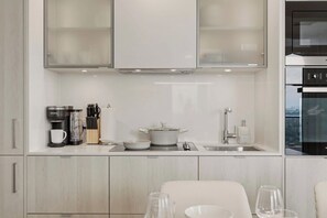 A modern kitchen with a coffee maker, utensils, a pot, and a sink. - 2BR Yorkville Retreat - Balcony & Views (Toronto)