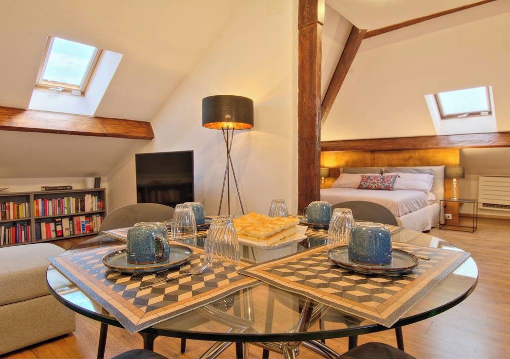 Een eethoek met een glazen tafel, geruit tafelonderleggers en een lamp.