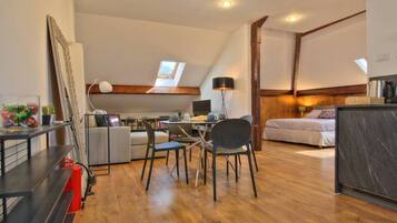 Une chambre moderne de style loft, comprenant un coin repas, un lit et un espace cuisine.
