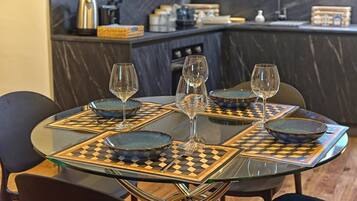 A dining table with four chairs, each with a glass top and a patterned placemat.