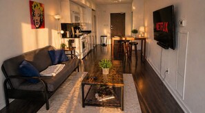 A modern living room with a sofa, coffee table, and a TV displaying the Netflix logo. - Modern 2BR Downtown Toronto Condo | Parking (Toronto)
