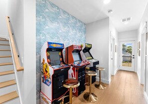 Ein Flur mit Spielautomaten, einer Treppe und einer Tür, die nach draußen führt.