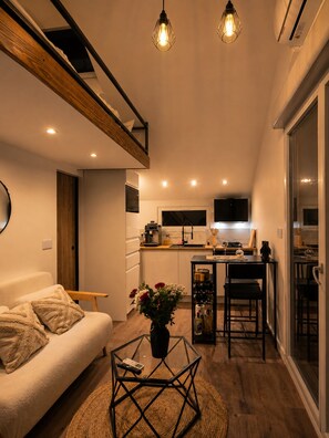 A compact living space with a kitchen, dining area, and a sofa with a coffee table.