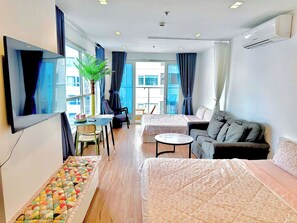 A modern hotel room with a bed, sofa, dining table, and a large window. - AYA LUXURY APARTMENT (ho chi minh)