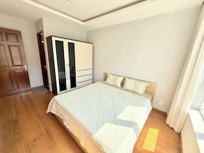 Ein Schlafzimmer mit Bett, Kleiderschrank und einer Tür.
