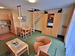 Ein kompakter Wohnbereich mit Essbereich, Küchenzeile und einem eingebauten Fernsehschrank.