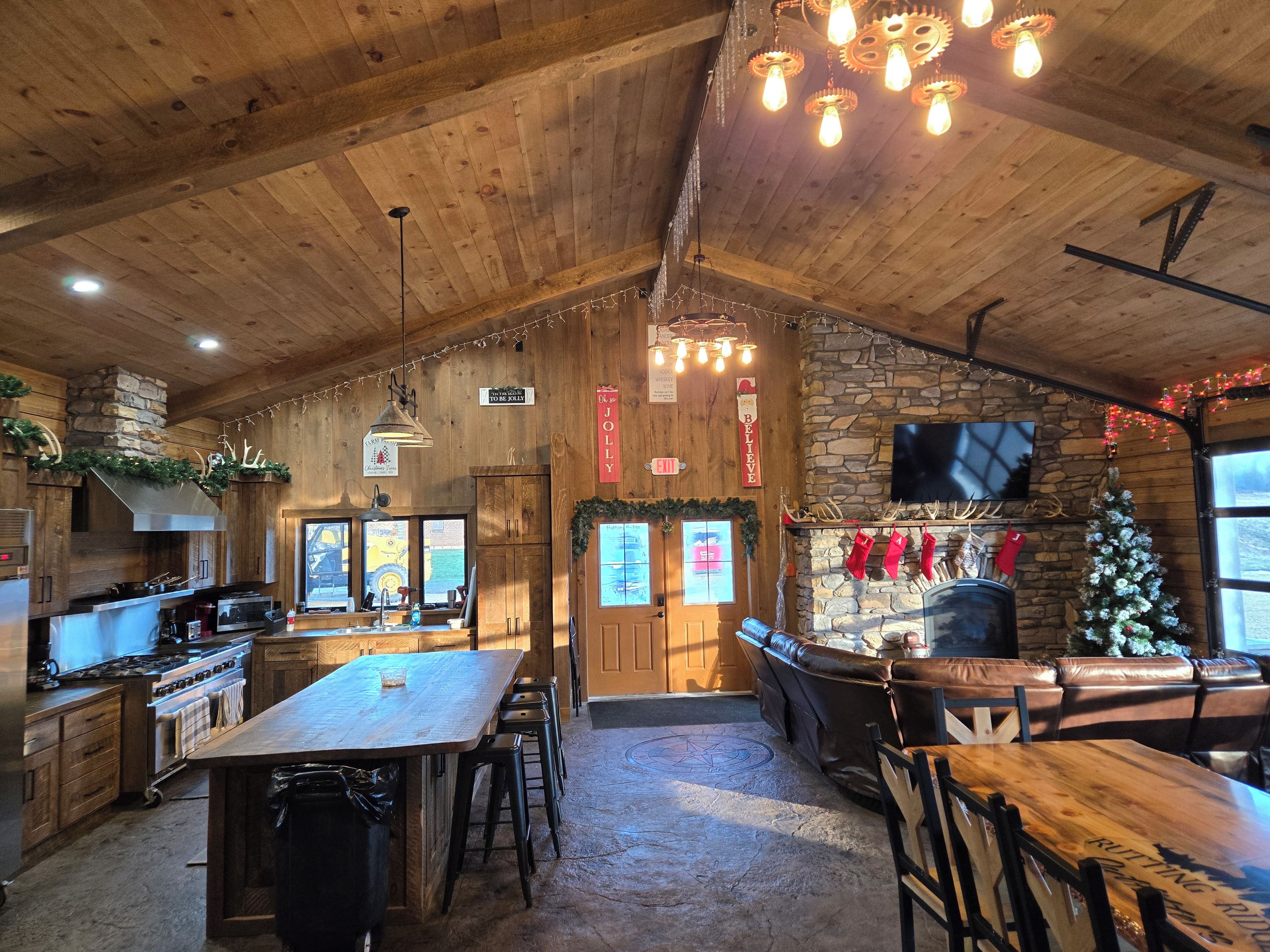 Un intérieur rustique avec un plafond en bois, une cheminée en pierre et un coin bar doté de tabourets.