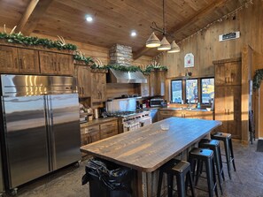 A modern kitchen with wooden cabinets, stainless steel appliances, and a central island with bar stools.