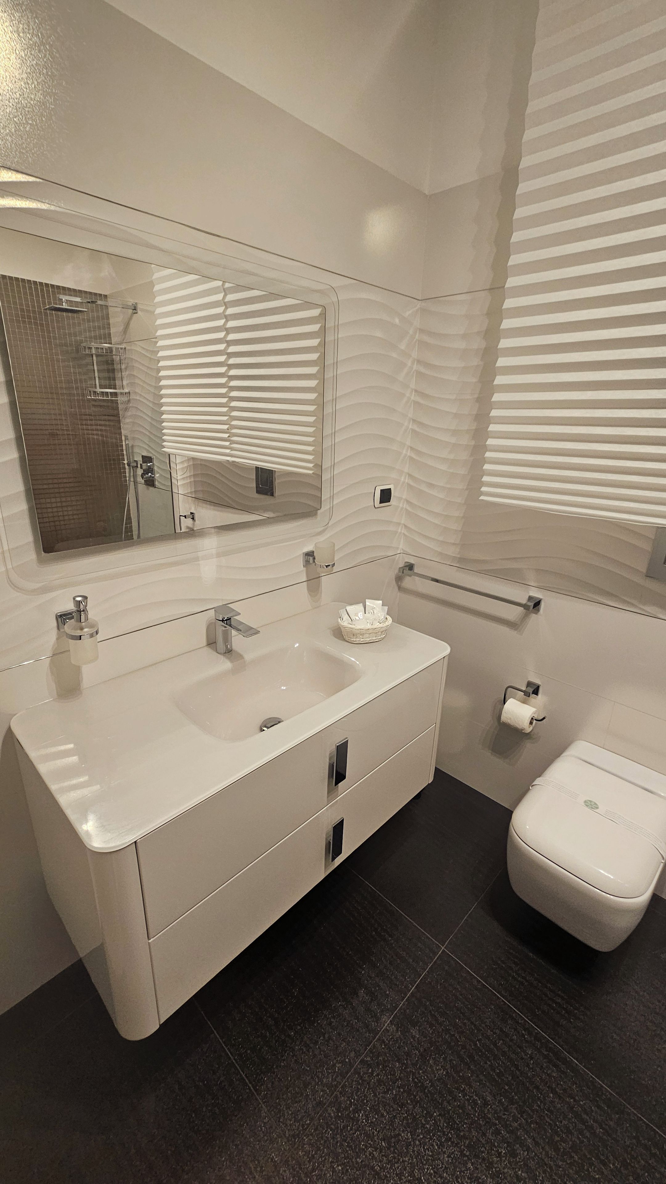 Ein modernes Badezimmer mit einem großzügigen Waschtisch, Toilette und einer Duschkabine.
