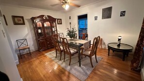 A dining area with a wooden table, chairs, a cabinet, and a small round table with a lamp. - The Lighthouse- Furnished 2BR Retreat on Gated Estate- 31+ Night Stays (McDonough)