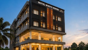 Ett hotell med flera våningar, med en tydlig skylt som visar texten ”HOTEL WHITE HOUSE”.