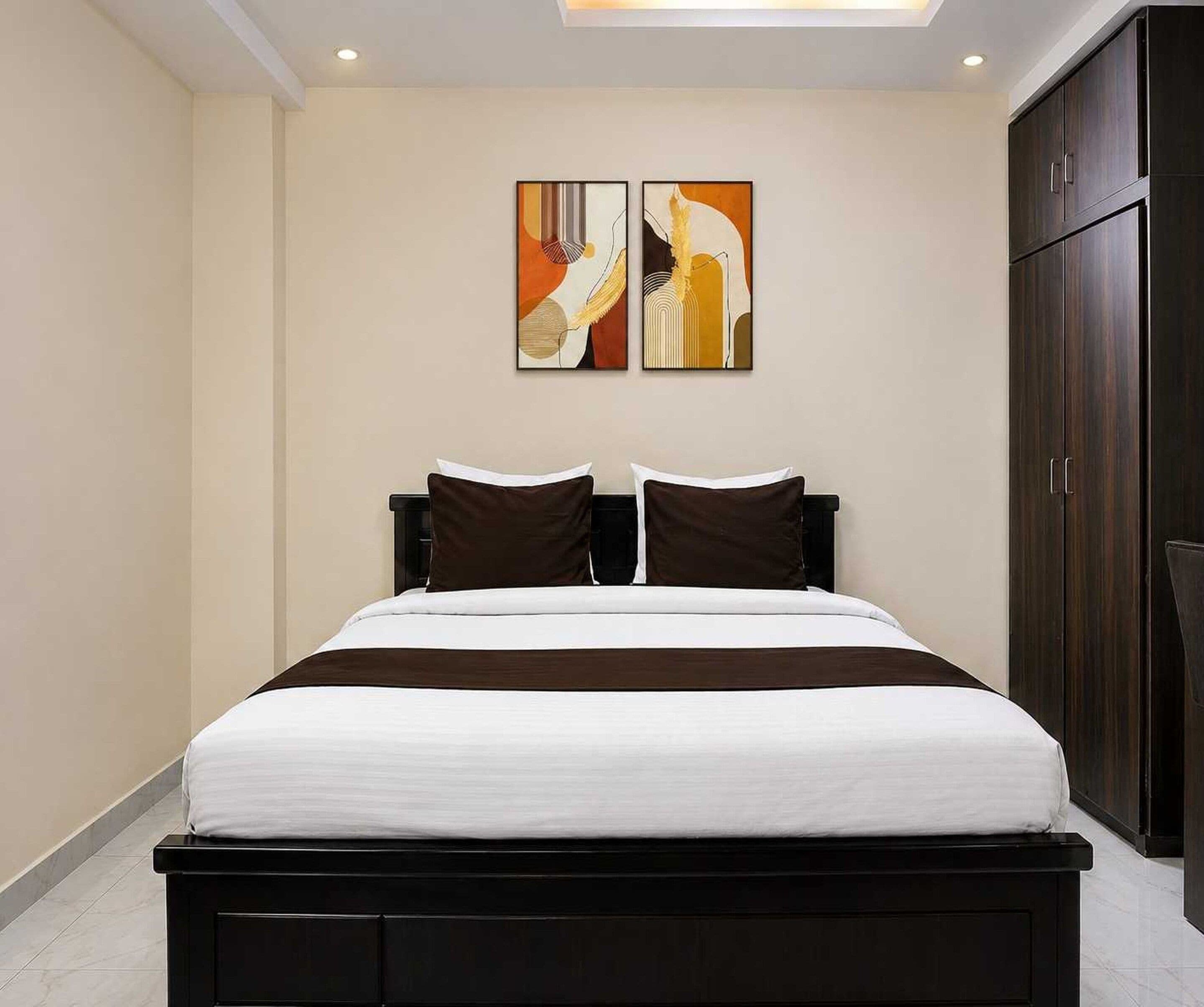 A bedroom with a bed, two pillows, a headboard, and a wardrobe.