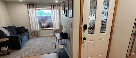 A living room with a sofa, a coffee table, and a door with a frosted glass panel.