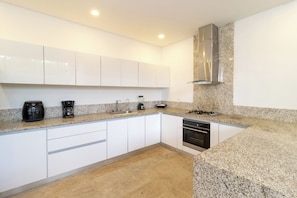 A modern kitchen with white cabinets, a granite countertop, a built-in oven, and a stainless steel range hood. - Modern Luxury Villa with Resort Pool  Bright Open Spaces Near Cartagena Beaches (Bolívar)
