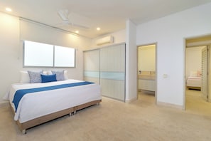 A modern bedroom with a bed, a wardrobe, and a bathroom visible through an open door. - Modern Luxury Villa with Resort Pool  Bright Open Spaces Near Cartagena Beaches (Bolívar)