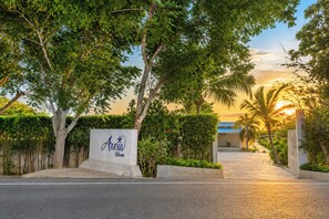A hotel entrance with a sign, pathway, and surrounding greenery. - Modern Luxury Villa with Resort Pool  Bright Open Spaces Near Cartagena Beaches (Bolívar)