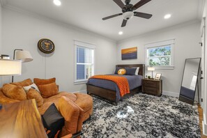 A bedroom with a bed, a nightstand, a lamp, a ceiling fan, and a window with blinds. - Welcome to Vol Haven – Your Home on Rocky Top! (Knoxville)
