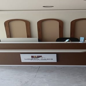 A reception desk with a sign reading 'URBAN OASIS by Anshul Design.' - Deluxe Hotel Urban Oasis (Pune)