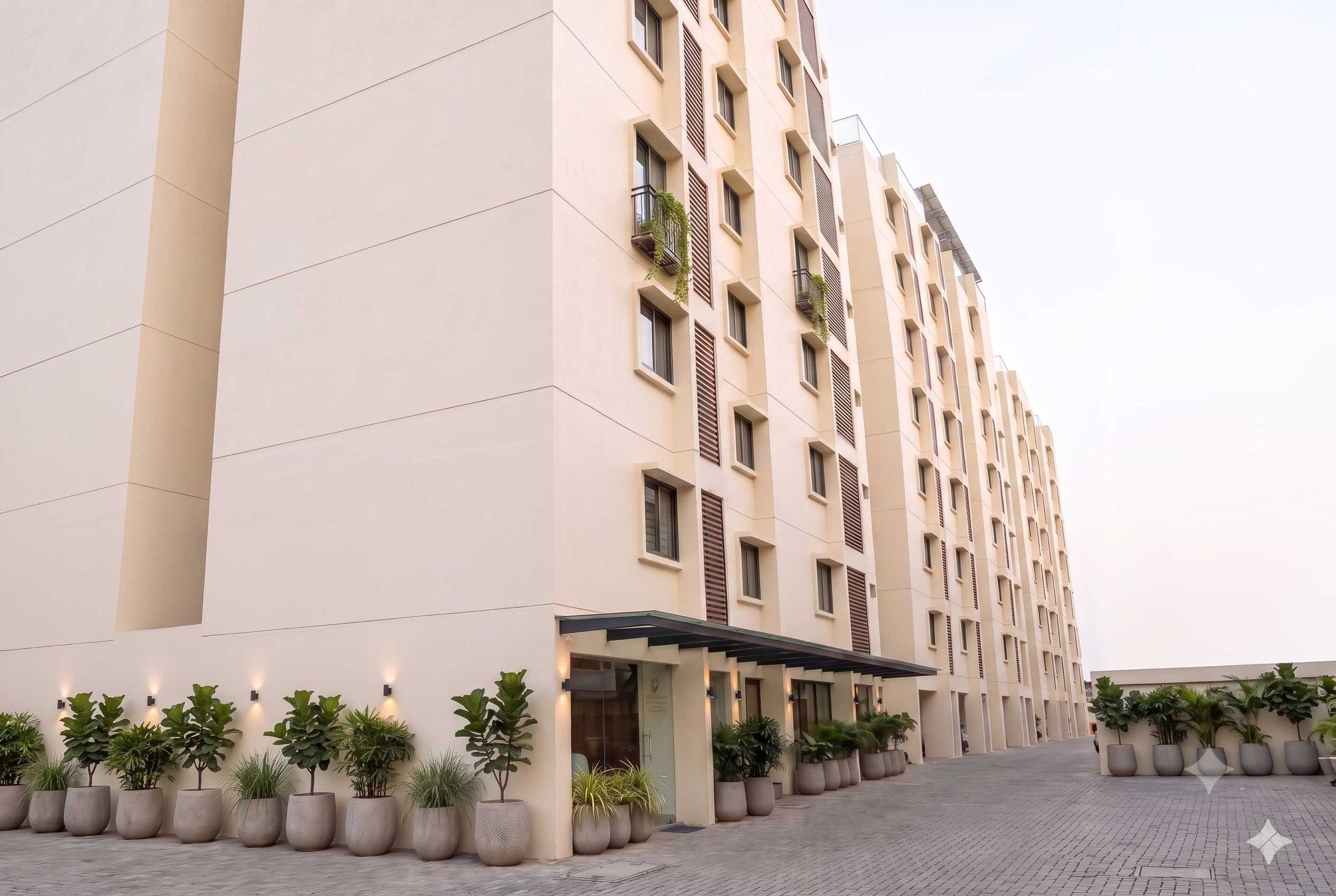 A multi-story hotel with a modern design, featuring a series of balconies and a covered entrance area.