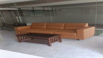 Un interior moderno con un sofá de cuero marrón y una mesa de centro de madera a juego.