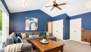 A living room with a sofa, coffee table, and a map on the wall.