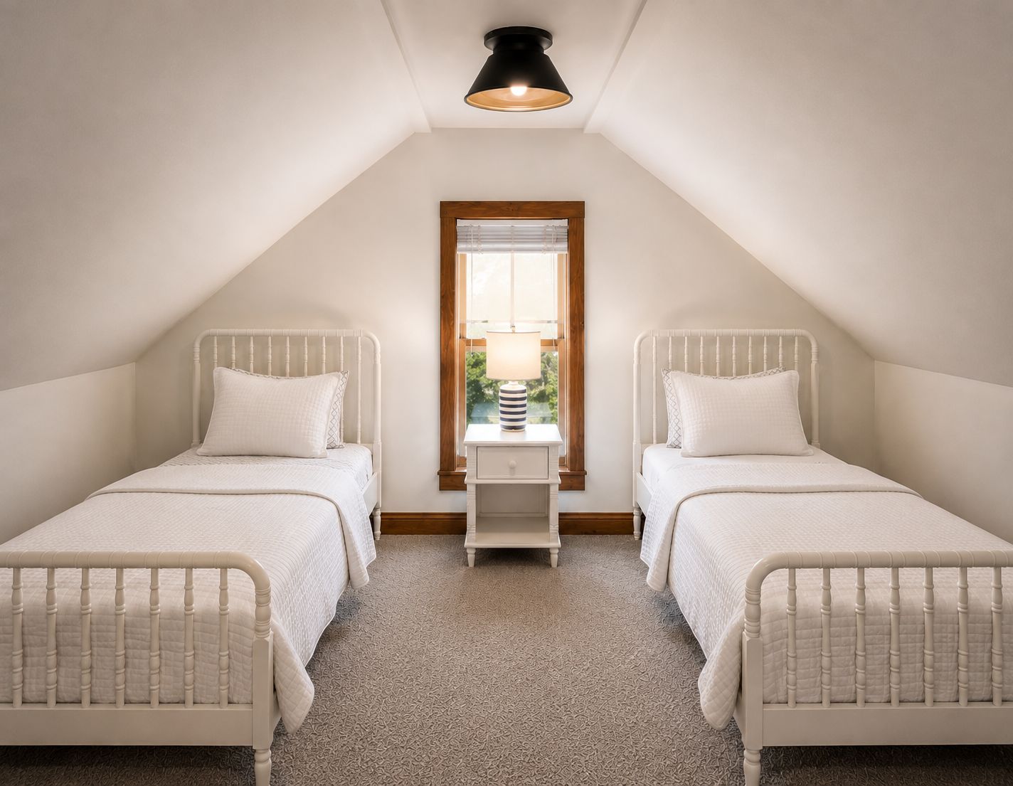 A bedroom with two single beds, a window with blinds, a bedside table with a lamp, and a ceiling light fixture.