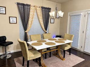 A dining area with a table, chairs, and a chandelier.