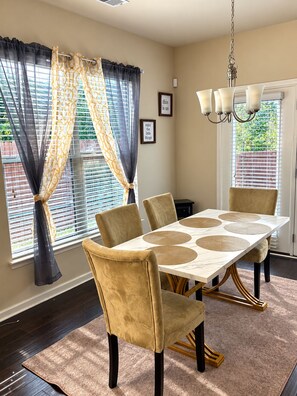 Un espace repas comprenant une table, des chaises et un lustre.