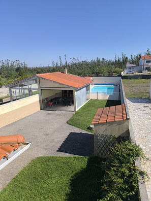 A residential property with a swimming pool, a covered patio, and a well-maintained lawn. - Maison avec piscine privée (Amor)