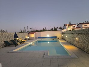 A swimming pool with lounge chairs and a stone wall. - Maison avec piscine privée (Amor)