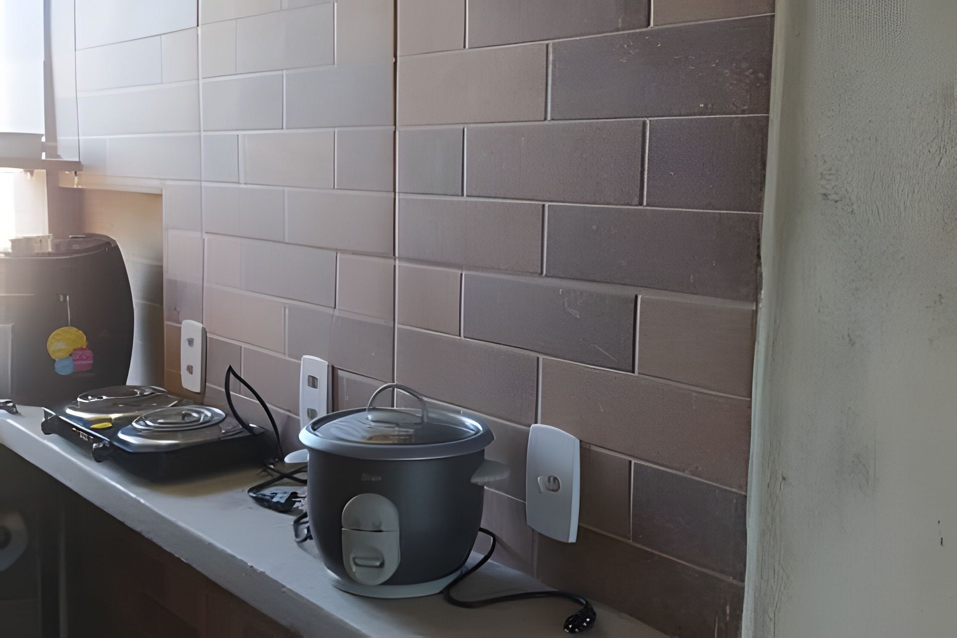 A kitchen with a countertop, a slow cooker, and a coffee maker.