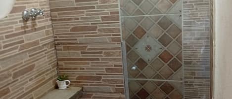 A bathroom with a shower, toilet, and a sink.