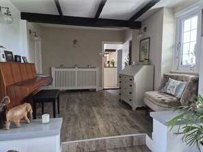 Une pièce avec un piano, un canapé, une commode et un radiateur.