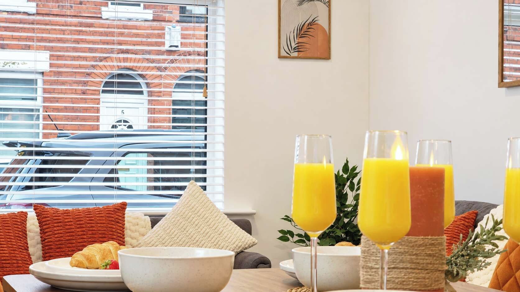 A breakfast setting with a table, a bowl of food, and three glasses of orange juice.