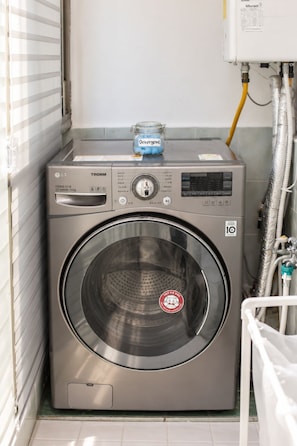 A front-loading LG TROMM washing machine with a detergent jar on top, a control panel, and a 10-star rating sticker. - [SOYO] Serene 2-bedroom apartment with AC in vibrant Seoul (Mapo-gu)
