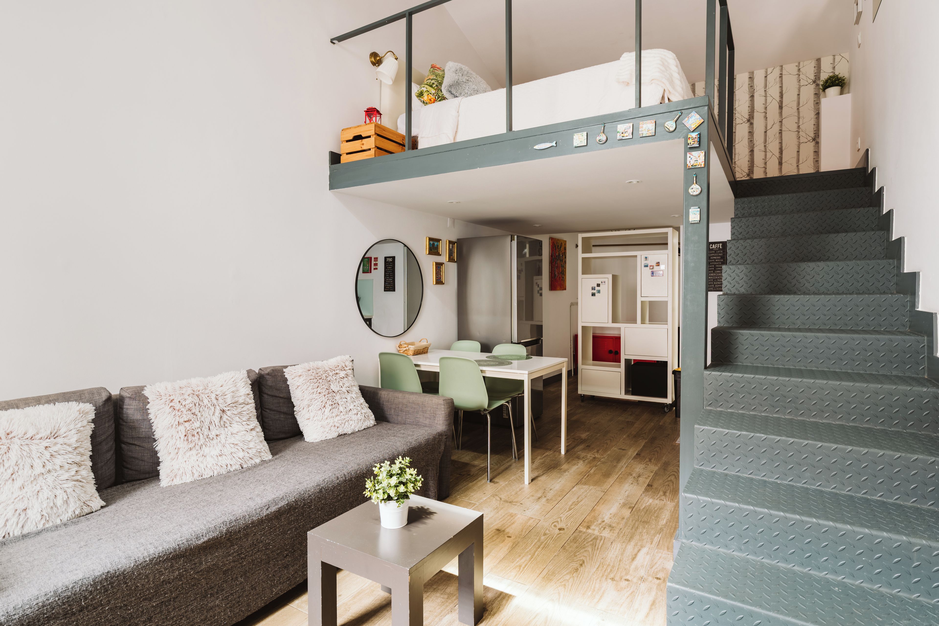 Un intérieur moderne avec un lit superposé, un coin repas et un escalier.