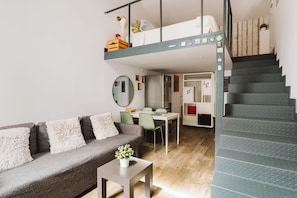 Ein modernes Interieur mit einem Etagenbett, einem Essbereich und einer Treppe.