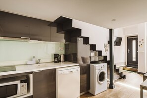 Una cucina compatta con lavastoviglie, forno a microonde e forno integrato.