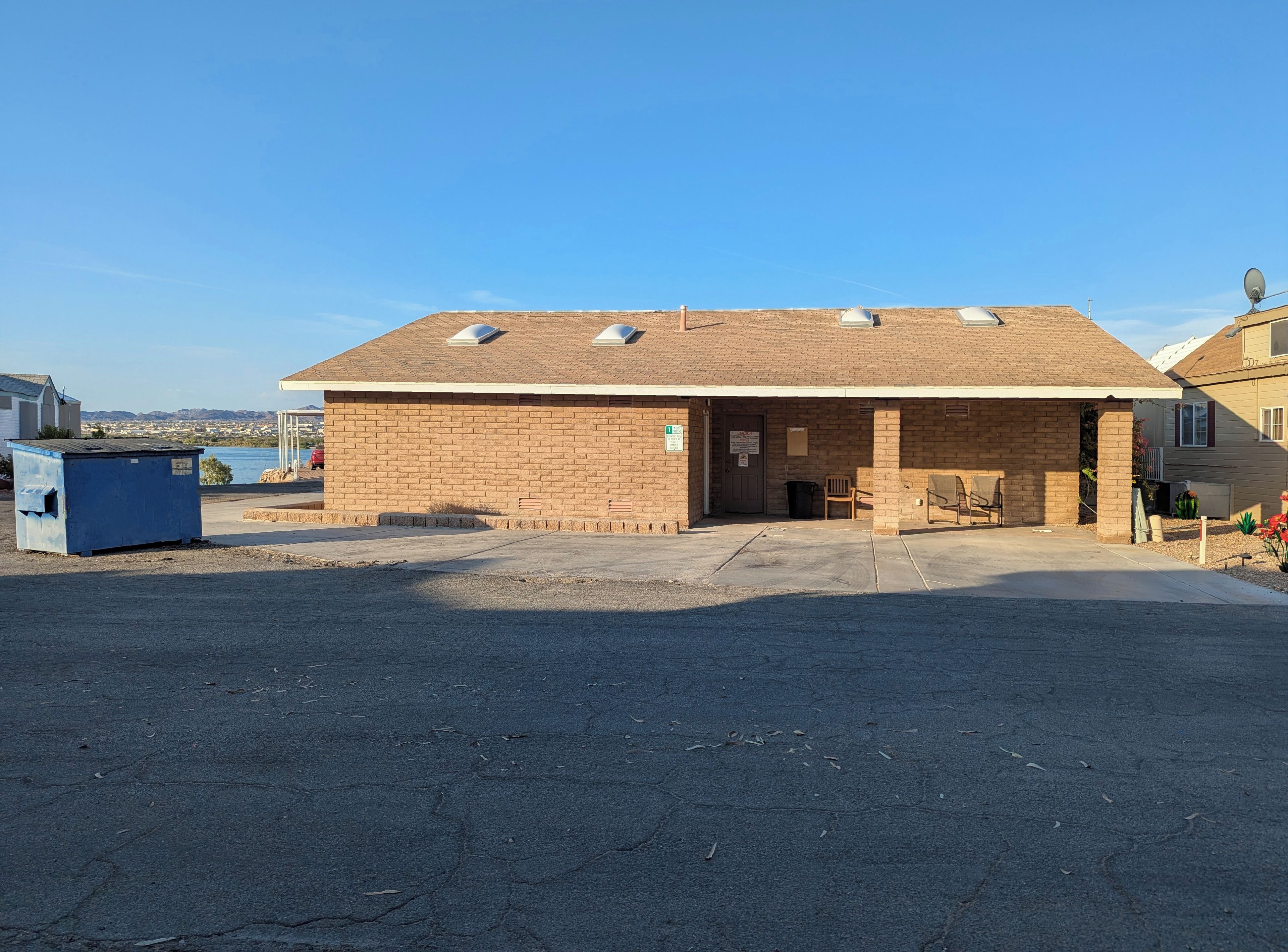 A single-story building with a brick facade, a covered entrance, and a clear sky.