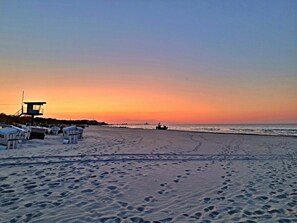 A beach with footprints, a lifeguard tower, and a row of beach huts. - Holiday Apartment With 1 Bedroom (Heringsdorf)