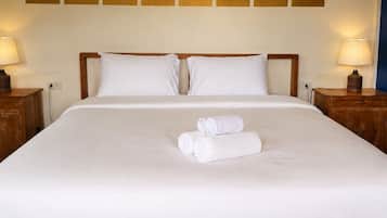 A hotel room with a large bed, two bedside tables, and a wall with a geometric pattern.